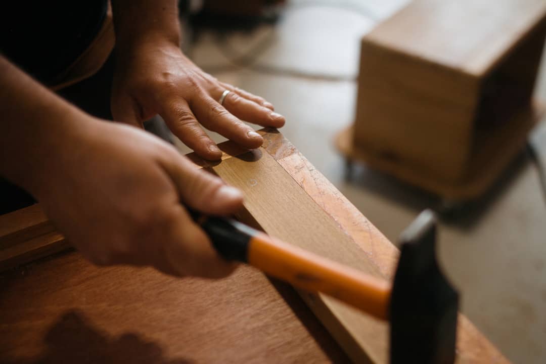 Un menuisier répare un meuble en bois